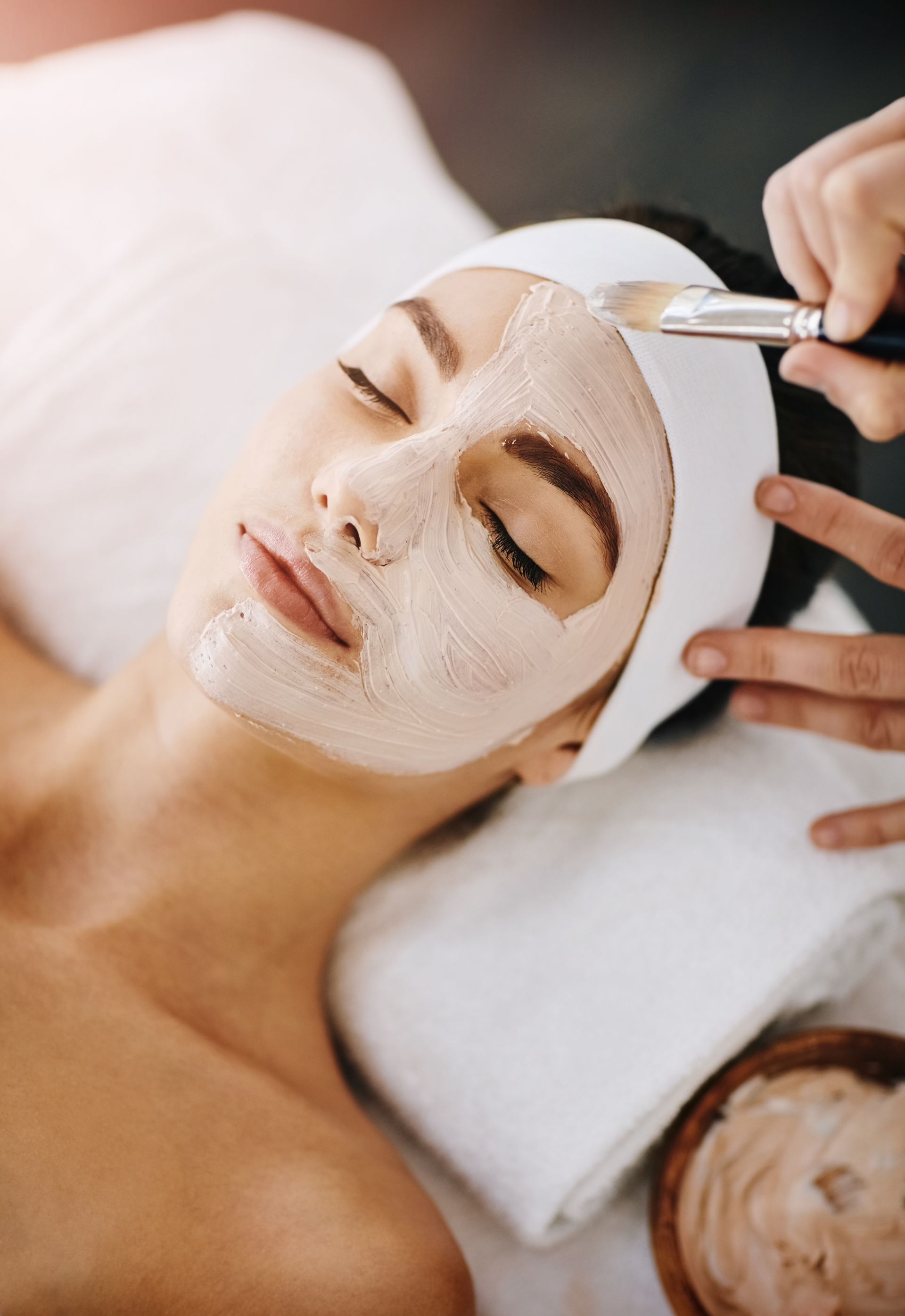 A woman is getting a facial treatment at a spa.