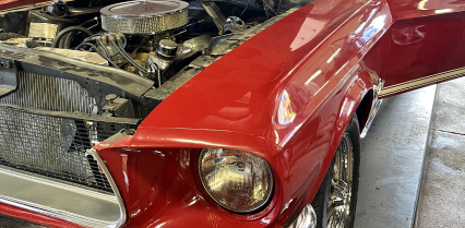 Red classic car with open hood, showing engine components, and open door. | Acadia Auto Service