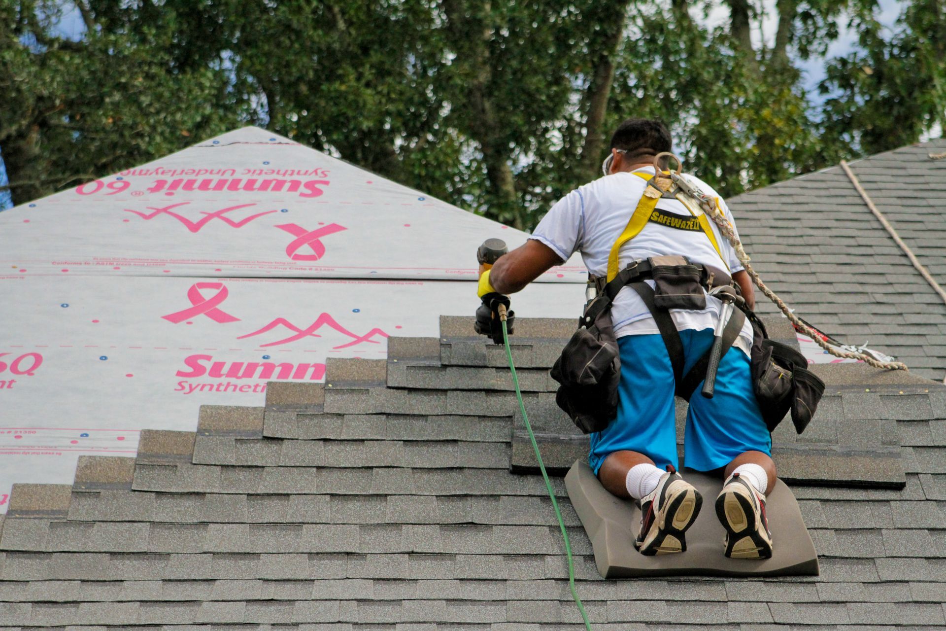 A man is working on the roof of a house.