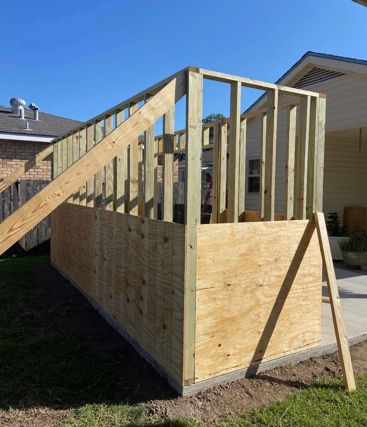 A wooden structure is being built in front of a house