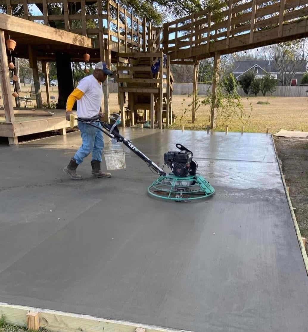 A man is using a machine to finish a concrete floor.