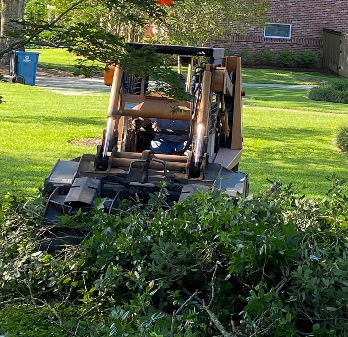 A man is driving a tractor through a lush green field.