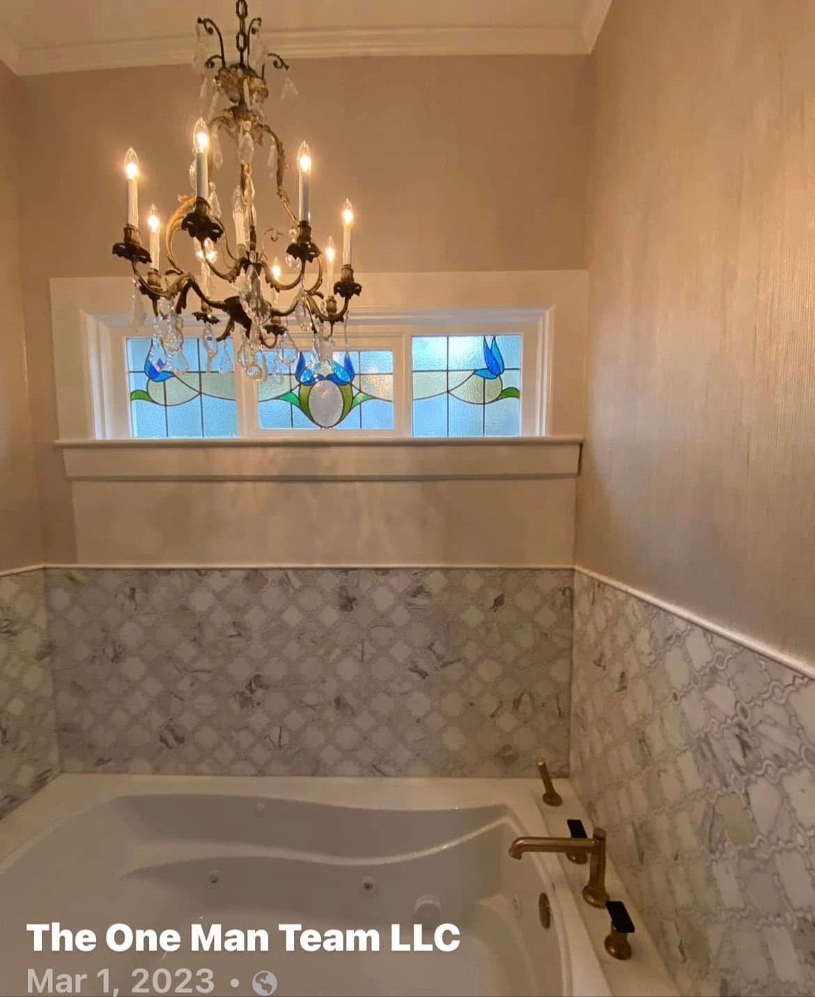 A bathroom with a jacuzzi tub and a chandelier hanging from the ceiling.
