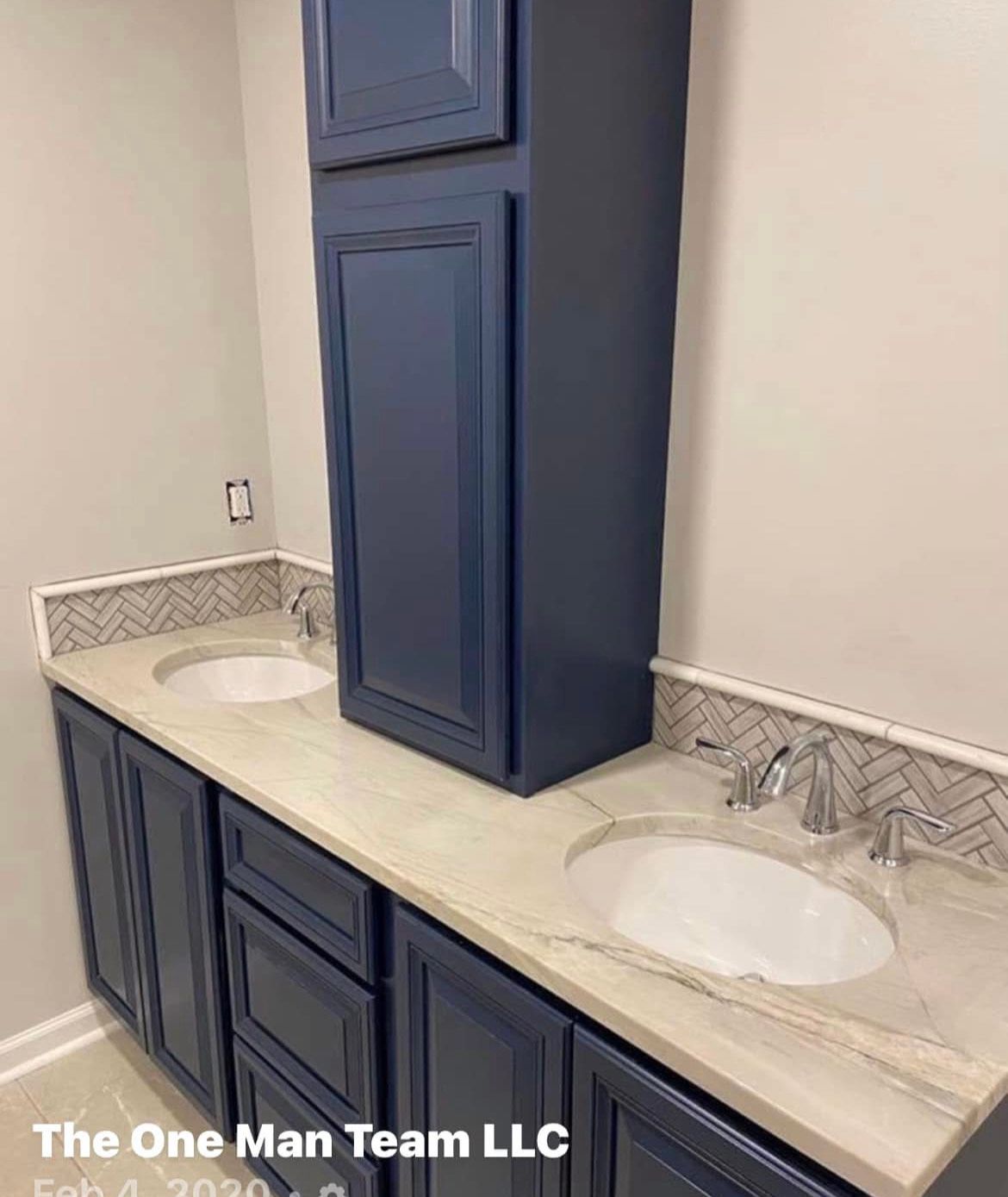 A bathroom with two sinks and a tall cabinet.