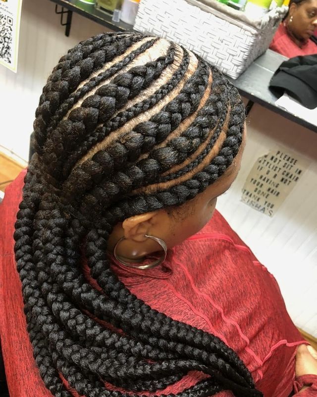 A woman in a red shirt has a braided hairstyle