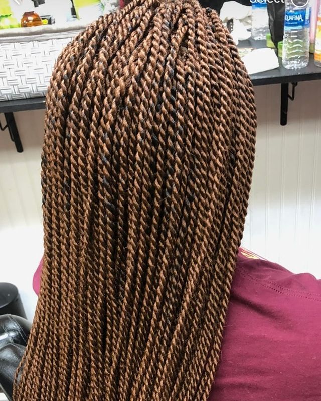 A woman with braids in her hair is sitting in front of a keyboard.