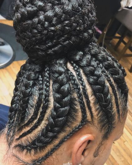 A close up of a woman 's braided hair in a bun.