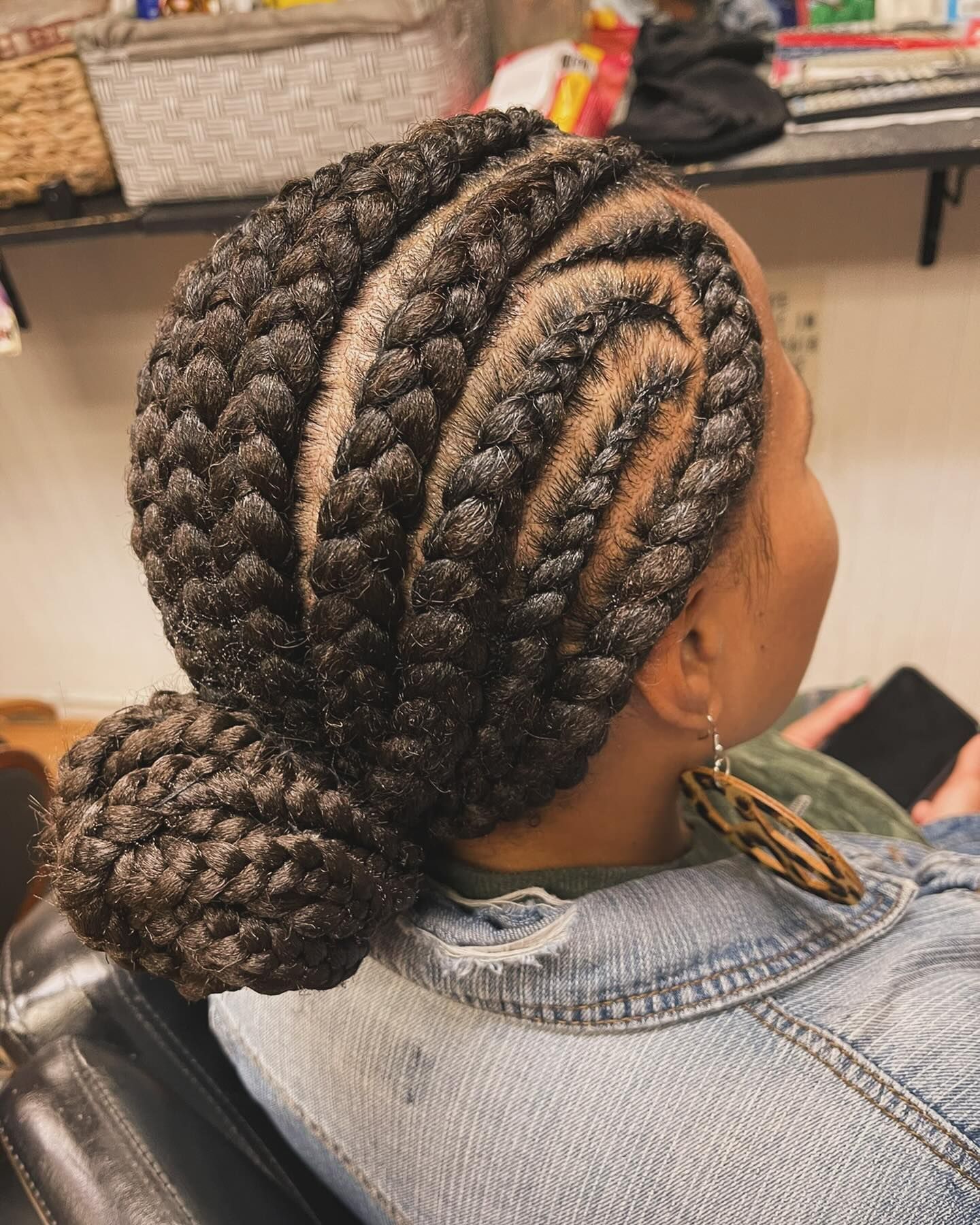 A woman is sitting in a chair with her hair in a bun.