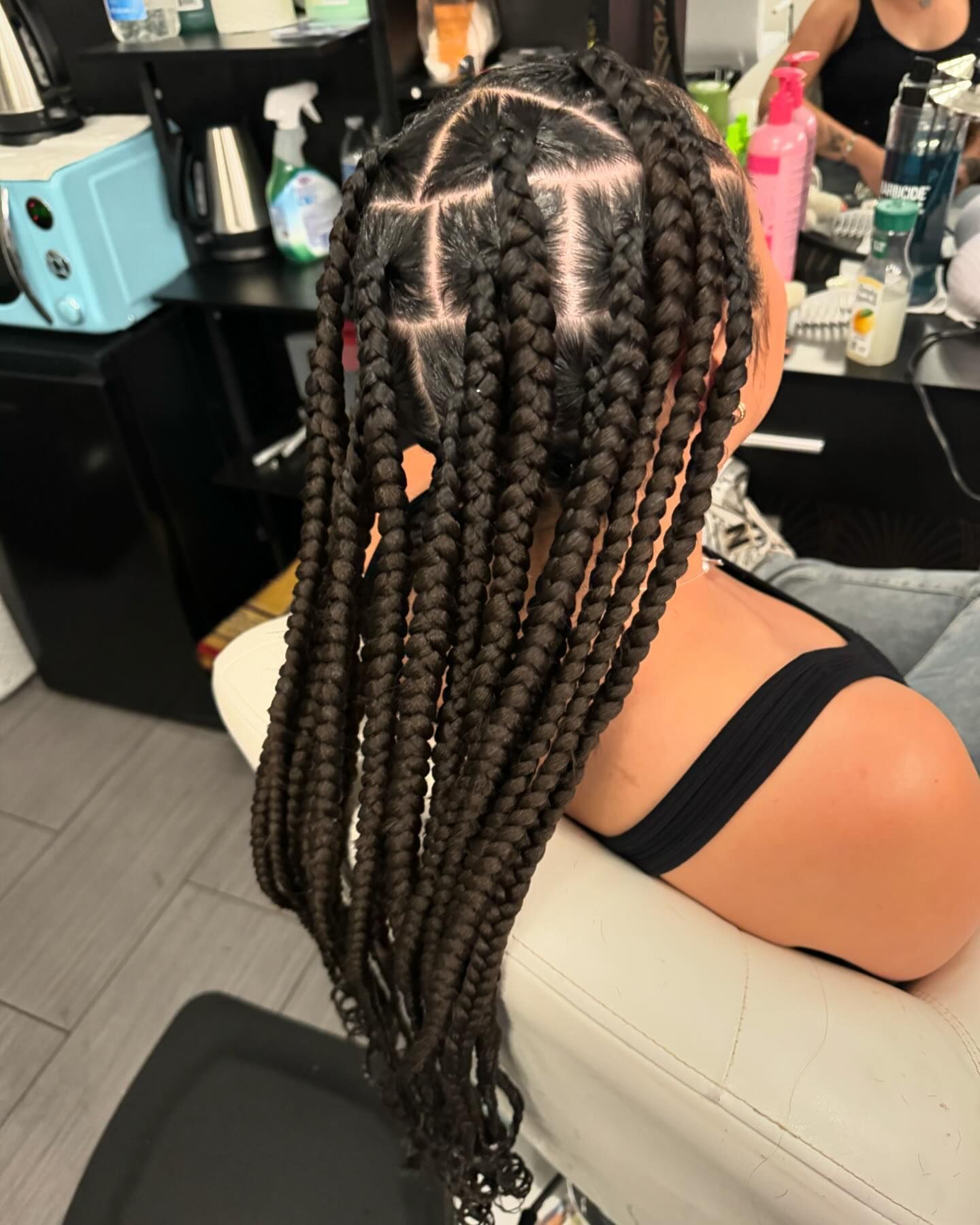 A woman with braids in her hair is sitting in a chair