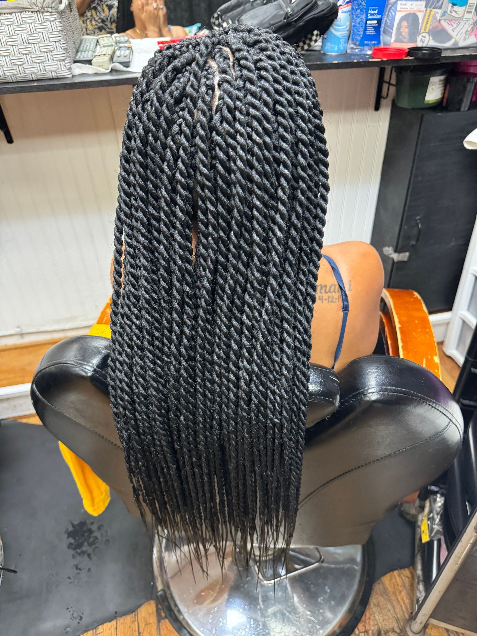 A woman is sitting in a chair with braids in her hair. | Los Angeles, CA | Aissata & Al Diouma