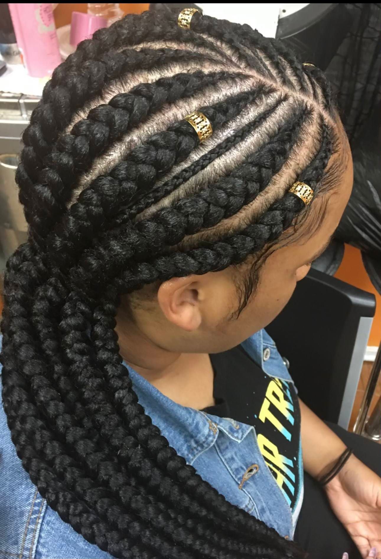 A woman with braids in her hair is wearing a denim jacket. | Los Angeles, CA | Aissata & Al Diouma