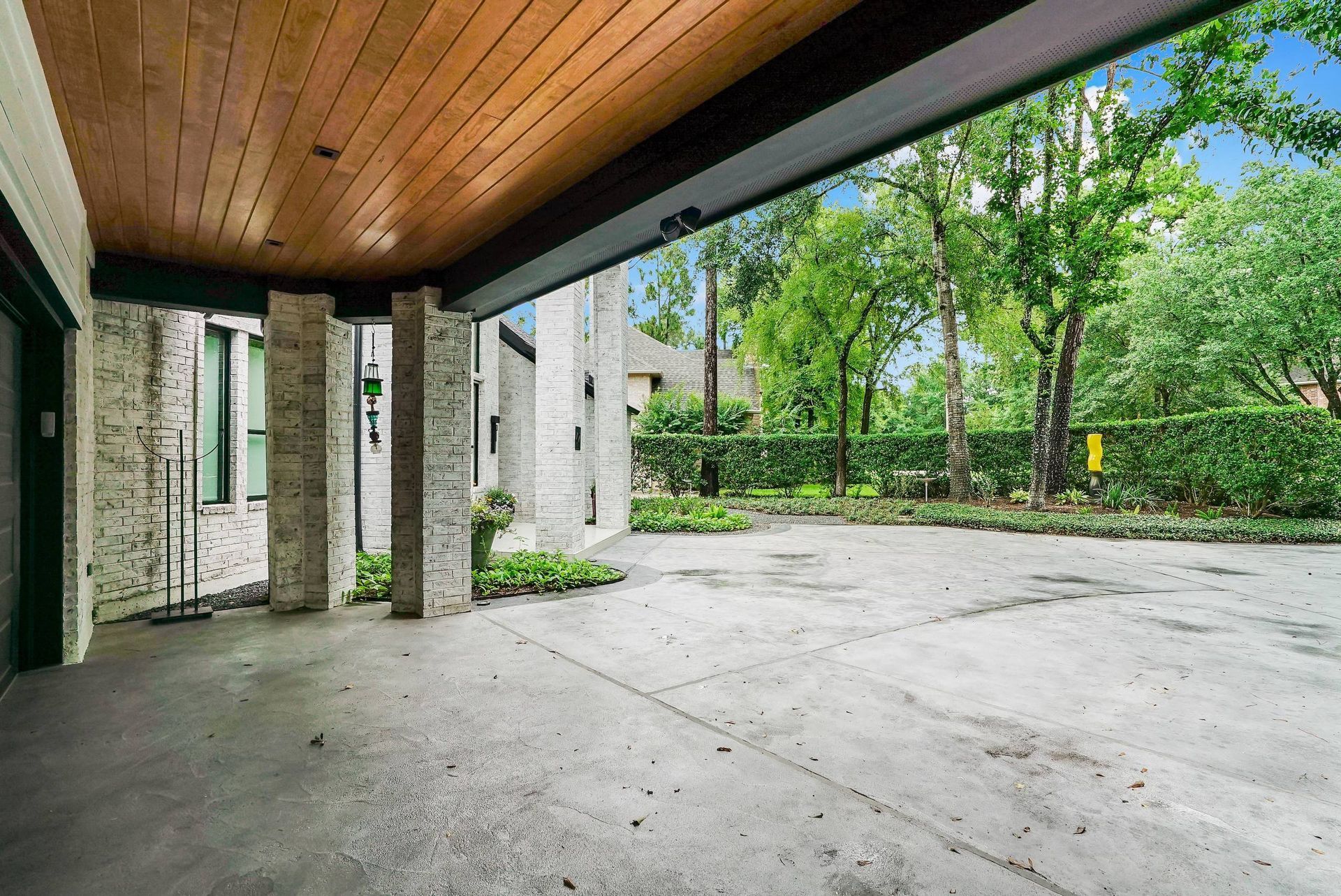An empty driveway with a wooden ceiling and trees in the background.