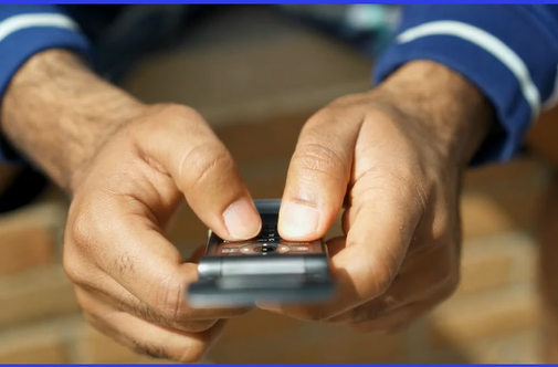 A person is holding a cell phone in their hands