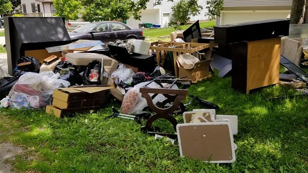 Large pile of household junk and furniture items on a lawn ready for removal by Junk Haul-Stars