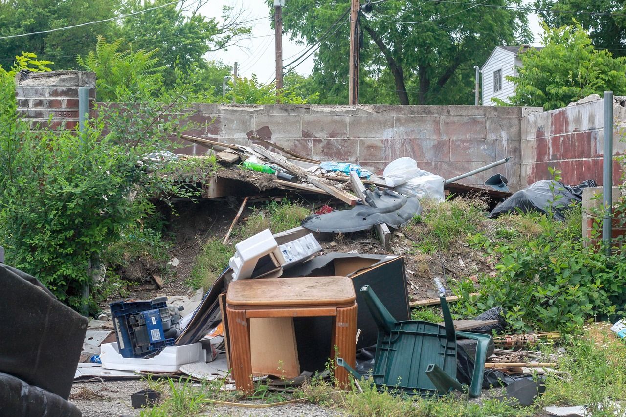 Backyard cluttered with branches, broken furniture, and yard waste | Junk Haul-Stars