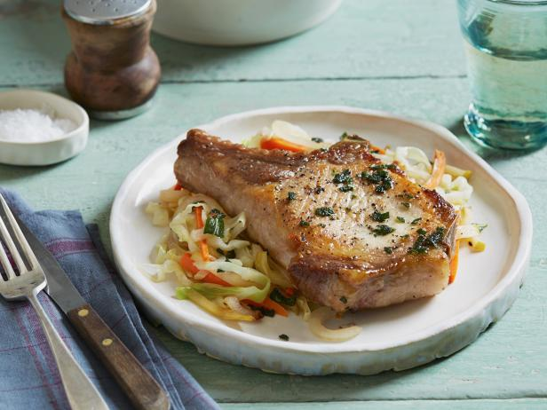 a white plate topped with meat and vegetables on a table .