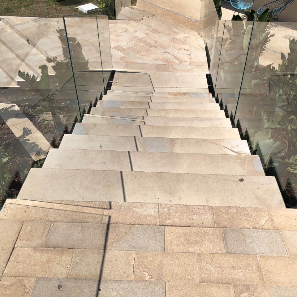 Scalinata in pietra con corrimano in vetro