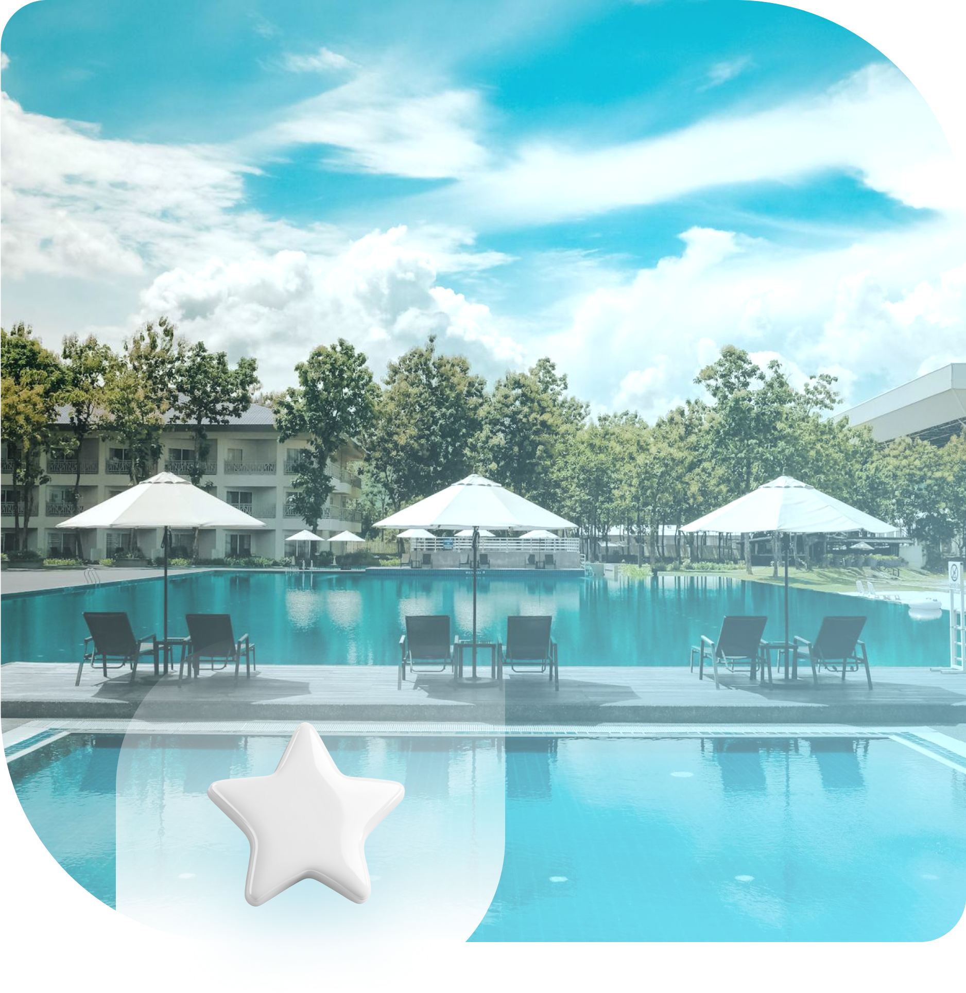 Swimming pool with umbrellas, lounge chairs, and a resort building on a sunny day.