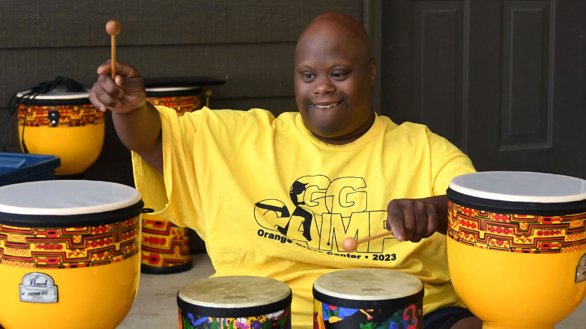 A camper plays with a set of different bongo drumps at Camp Double G.
