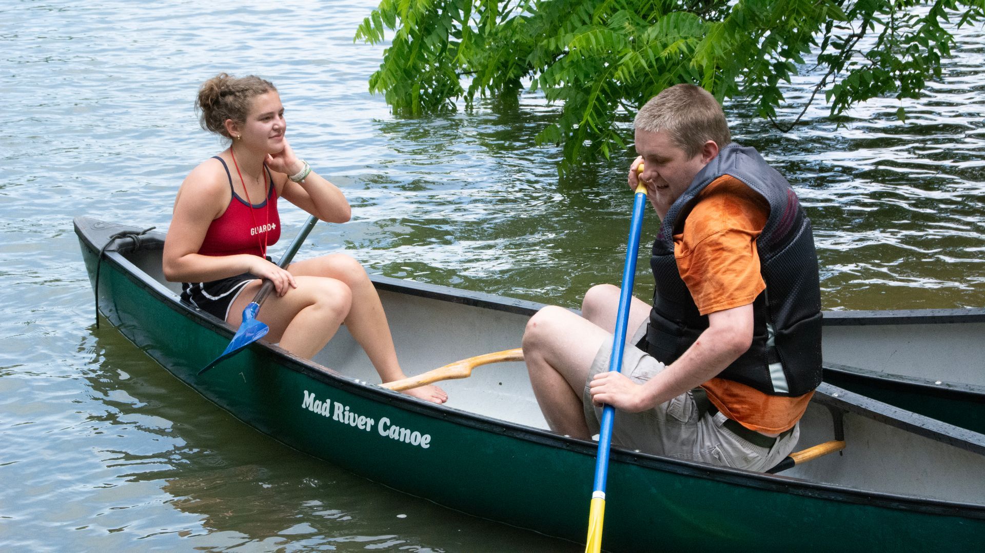 A camper and lifeguard prepare to set off in their canoe at Camp Double G.