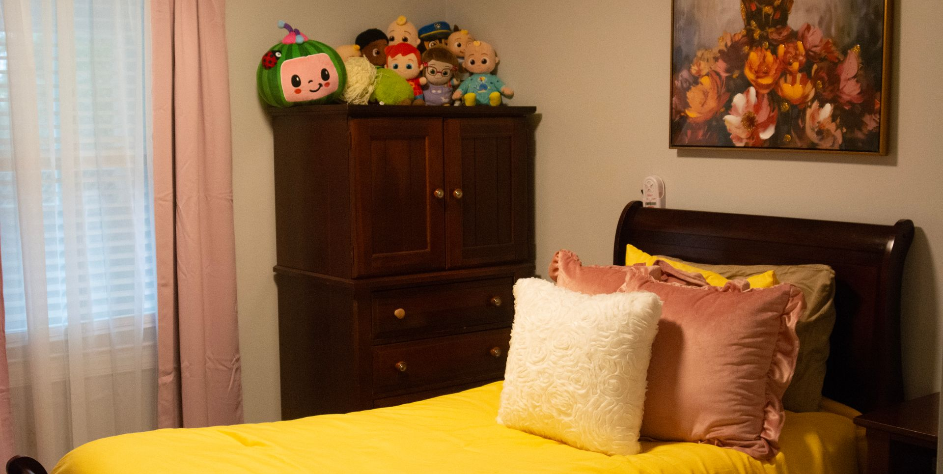 A bedroom featuring a bed with a neatly-made yellow blanket and pillows in an OGC residential home.