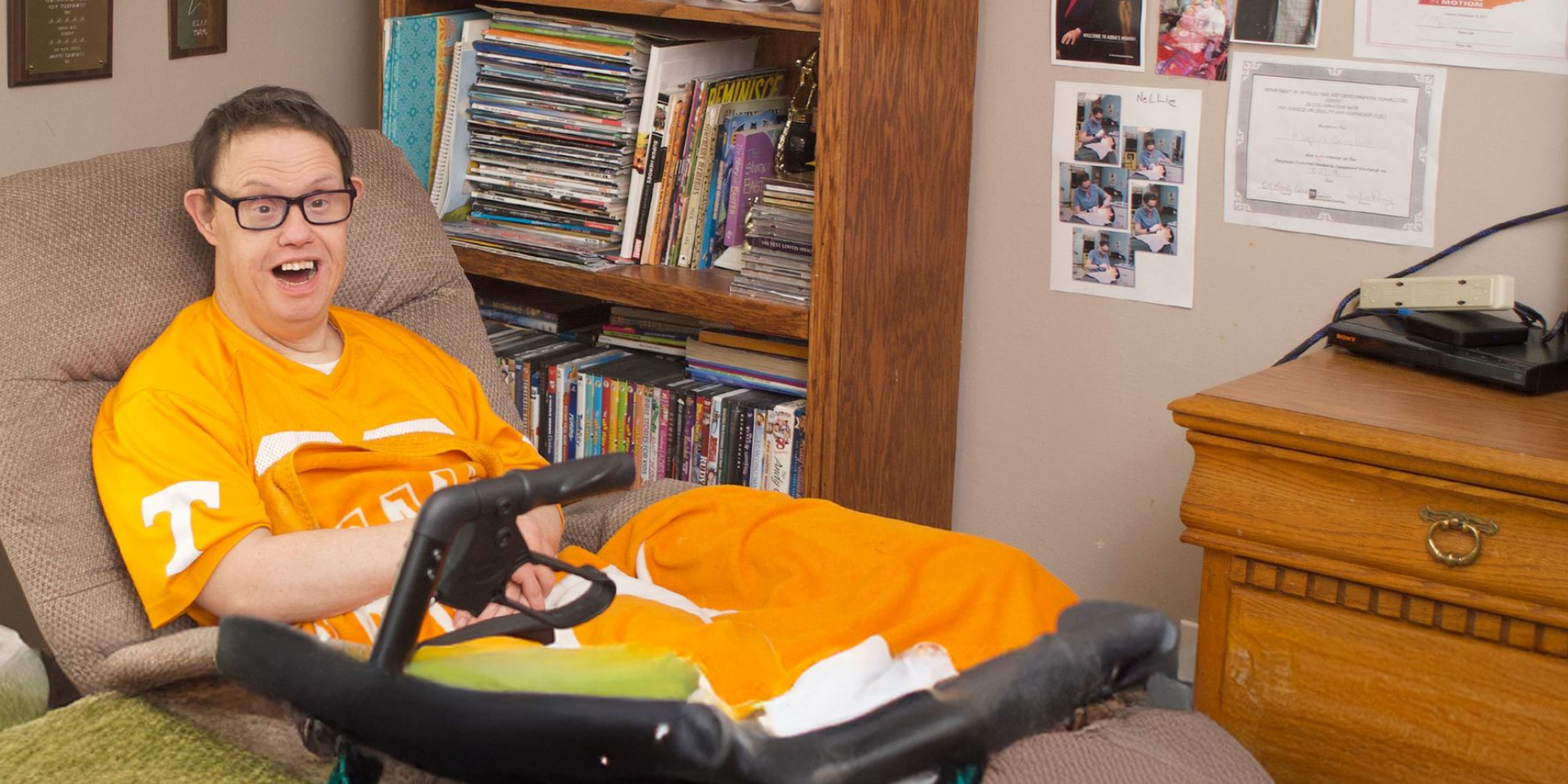 A gentleman served by Orange Grove's Residential Services smiling while reclining in his bedroom