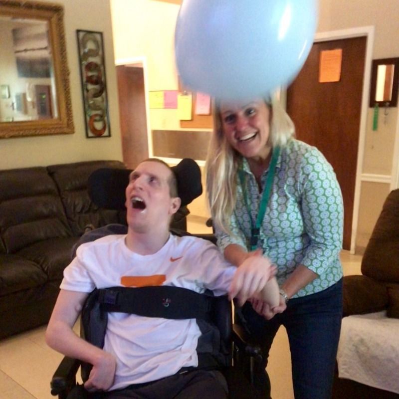 person in a wheel chair with a balloon