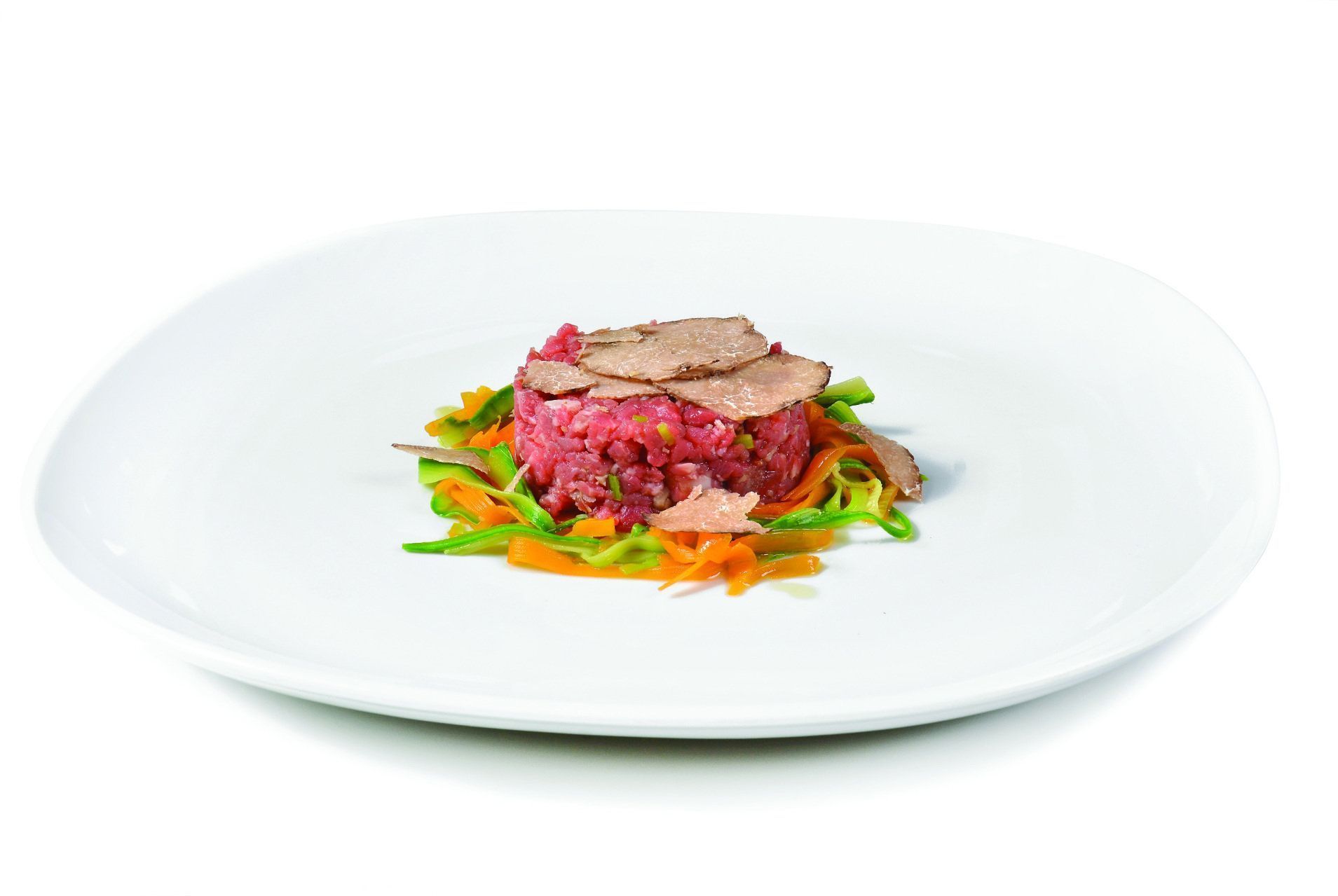 Un piatto bianco con carne e verdure su uno sfondo bianco.