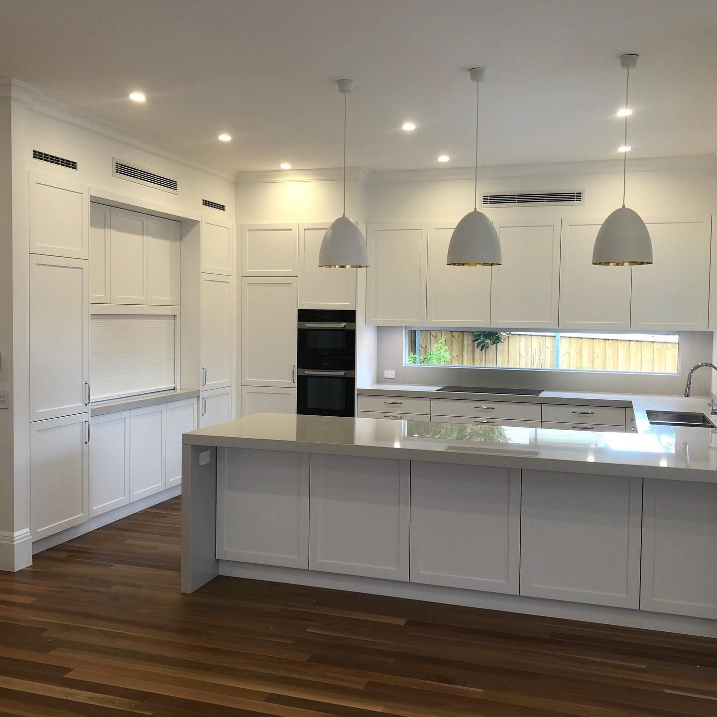 A woman wearing a hard hat and safety glasses is working on an electrical box.