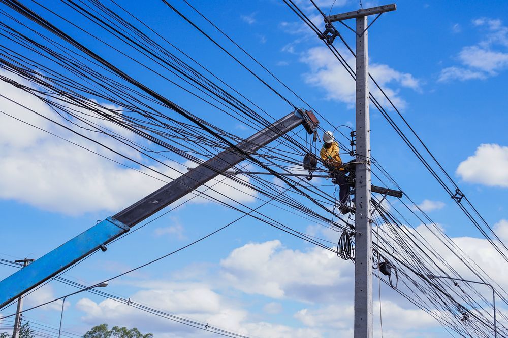 A Man is Working on a Power Pole With a Crane — J.A.F. Electrical Solutions in Kawana, QLD