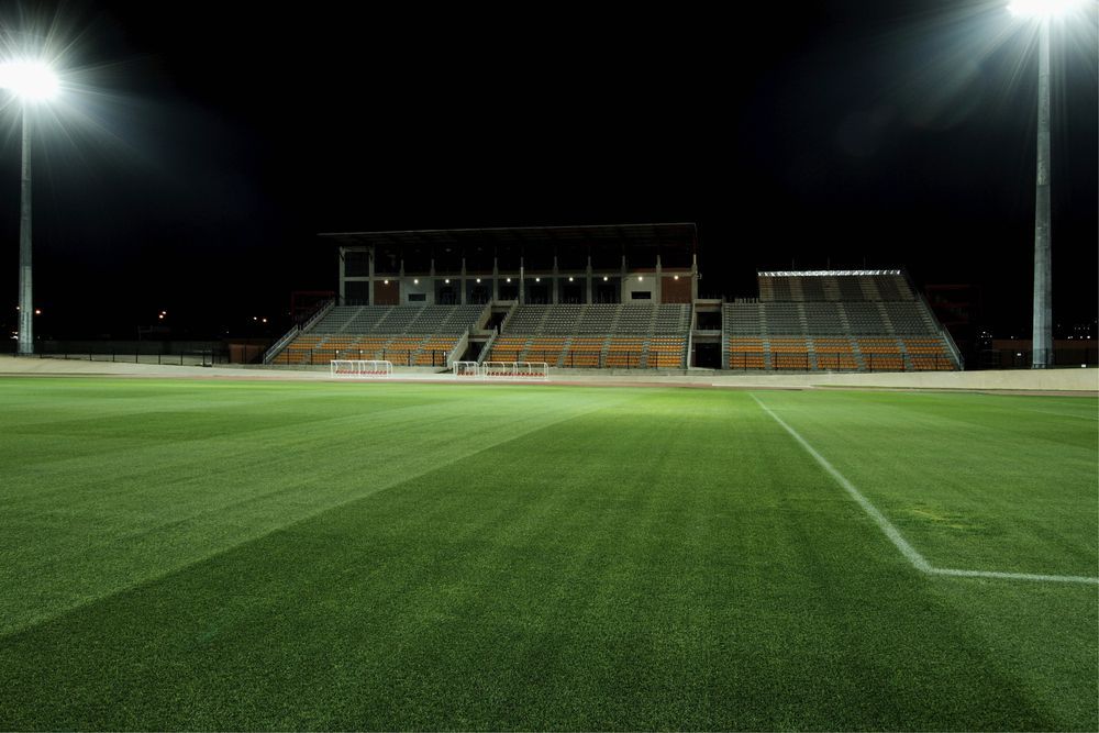 An Empty Soccer Field With a Stadium in the Background at Night — J.A.F. Electrical Solutions in Kawana, QLD