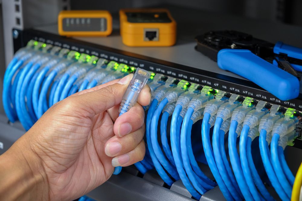 A Person is Holding a Wire in Their Hand in Front of a Bunch of Wires — J.A.F. Electrical Solutions in Kawana, QLD