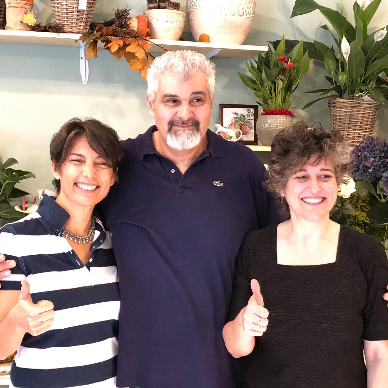 Tavolo bianco decorato con fiori bianchi e crema, verde e portacandele dorati.