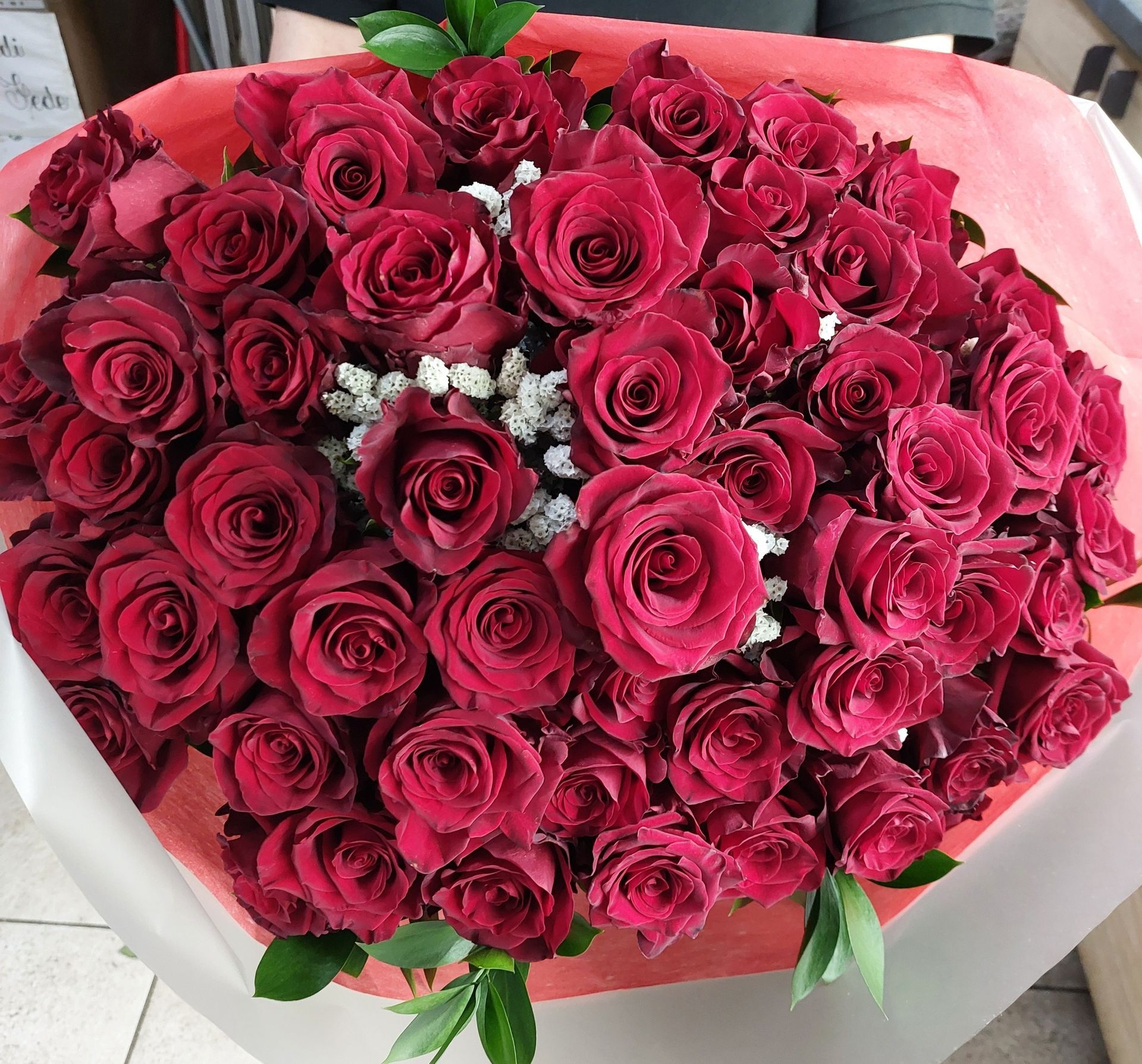 Tavolo bianco decorato con fiori bianchi e crema, verde e portacandele dorati.