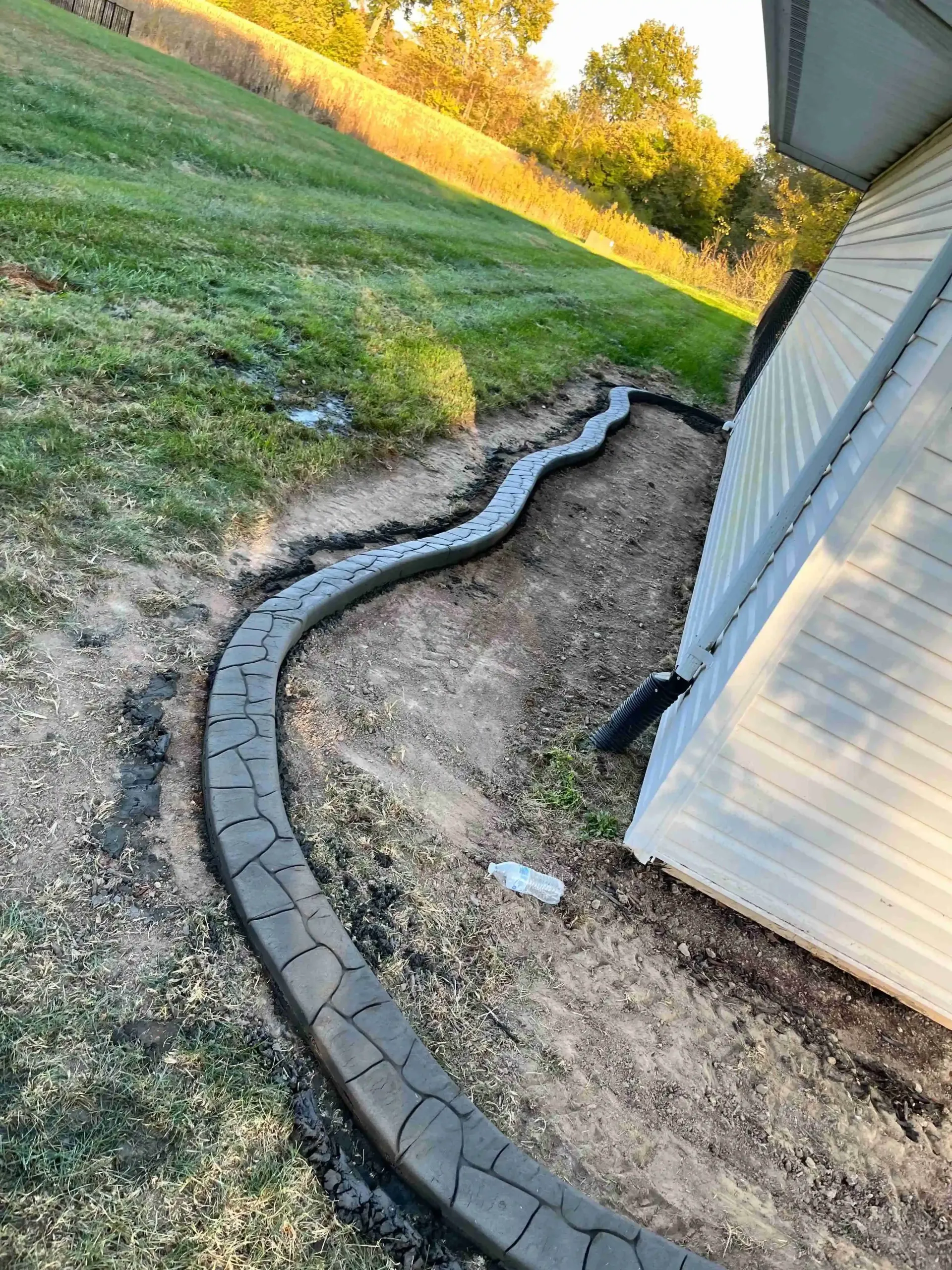 A brick walkway is being built next to a house.