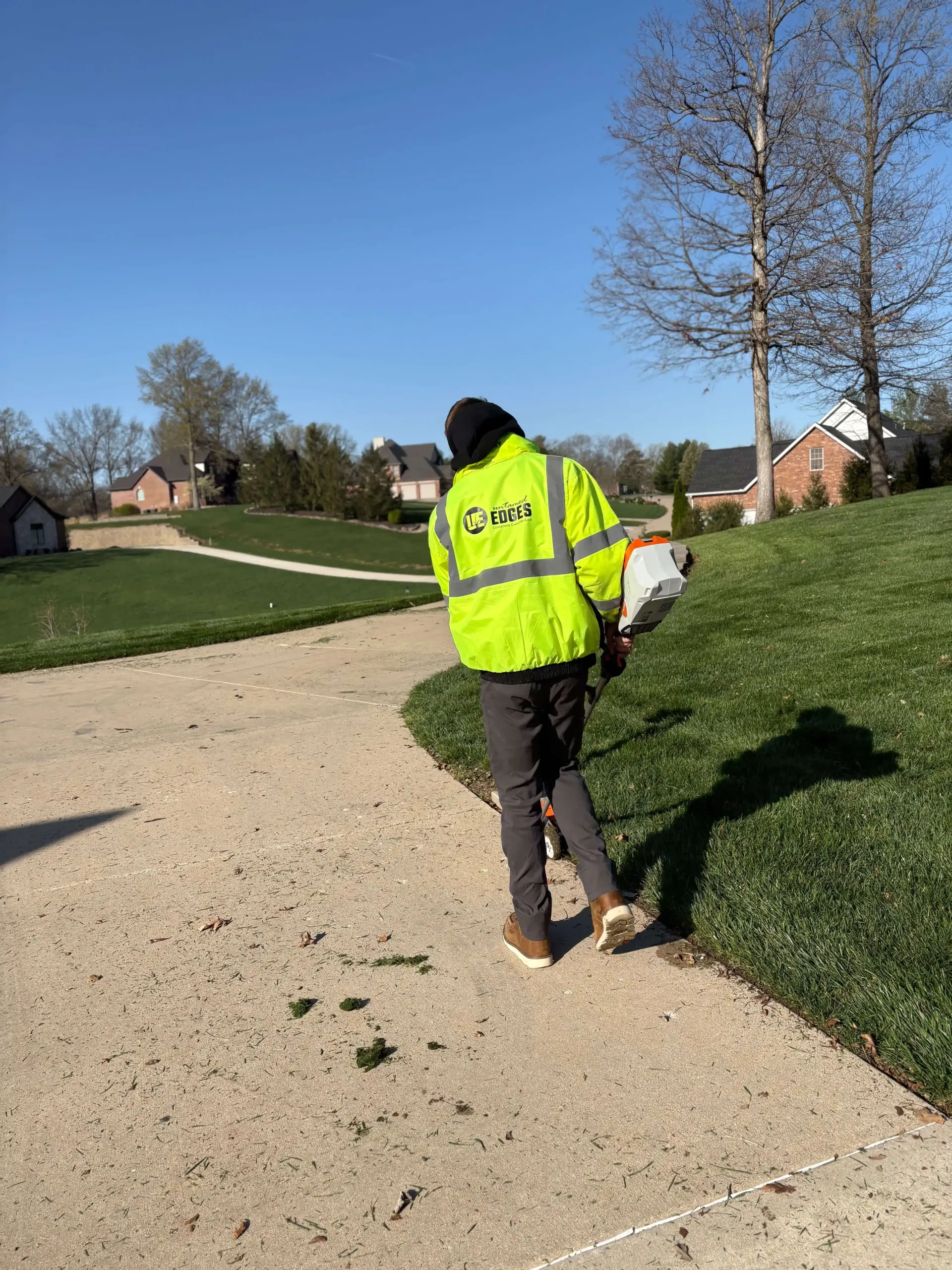 Untamed Edges team removing winter debris and pruning perennials during spring yard cleanup