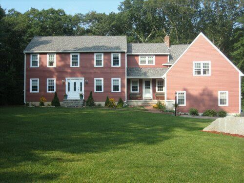 Large red-brick house with white trim and a green lawn in front