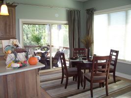 Dining room and kitchen with table, chairs, fruit bowl, and sliding glass doors to a patio