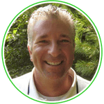 Smiling person with short blond hair, framed by a green circular border, against a leafy outdoor background