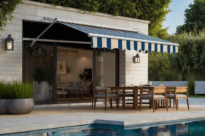 Exterior of a home with awning shading a patio dining set next to a pool. Shades & Awnings | MasterCraft Roofing, Siding & Windows | Serving Eastern MA, NH & Selected Areas of VT
