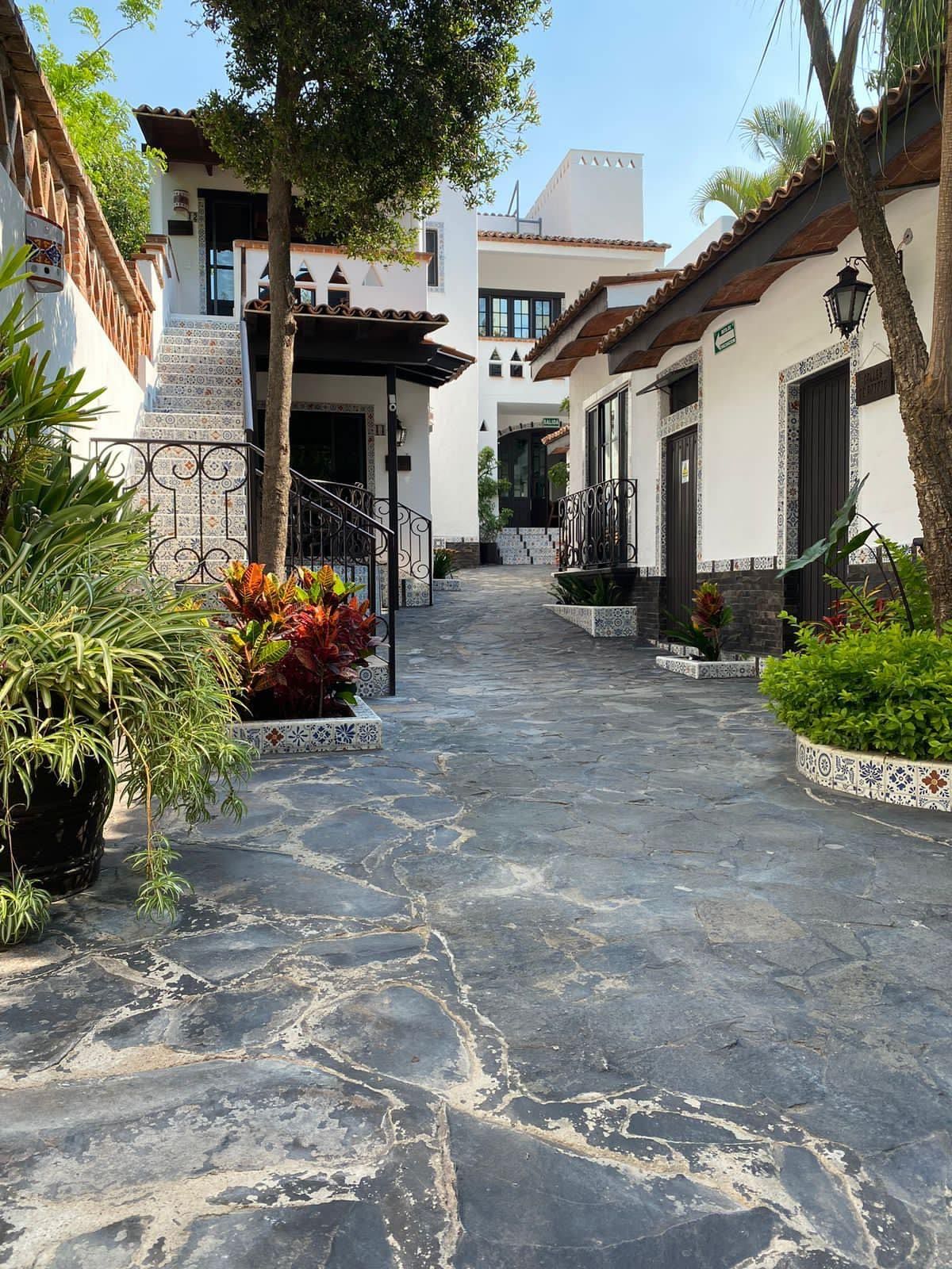 Un camino de piedra que conduce a un edificio blanco.