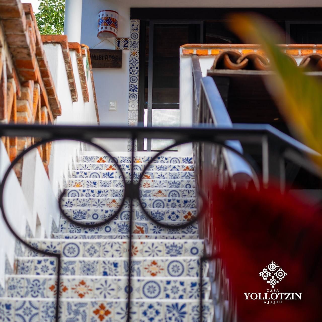 Una escalera con barandilla de hierro forjado y un cartel que dice yollotzin