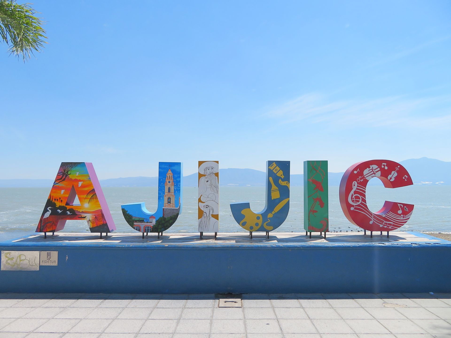 La palabra ajjic está escrita con letras coloridas en una pared azul.