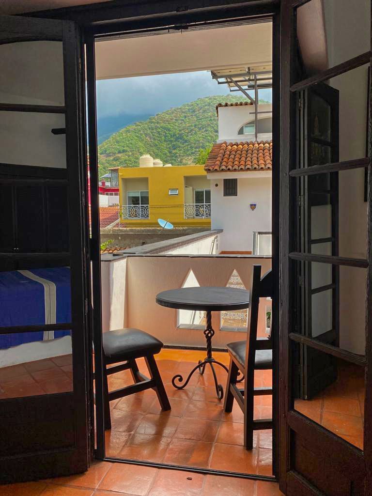 Un balcón con mesa y sillas y vista a la ciudad.