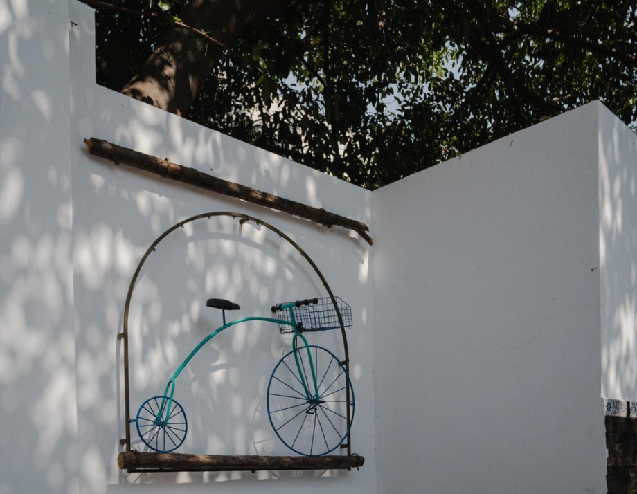 Una bicicleta con una cesta está colgada en una pared blanca.