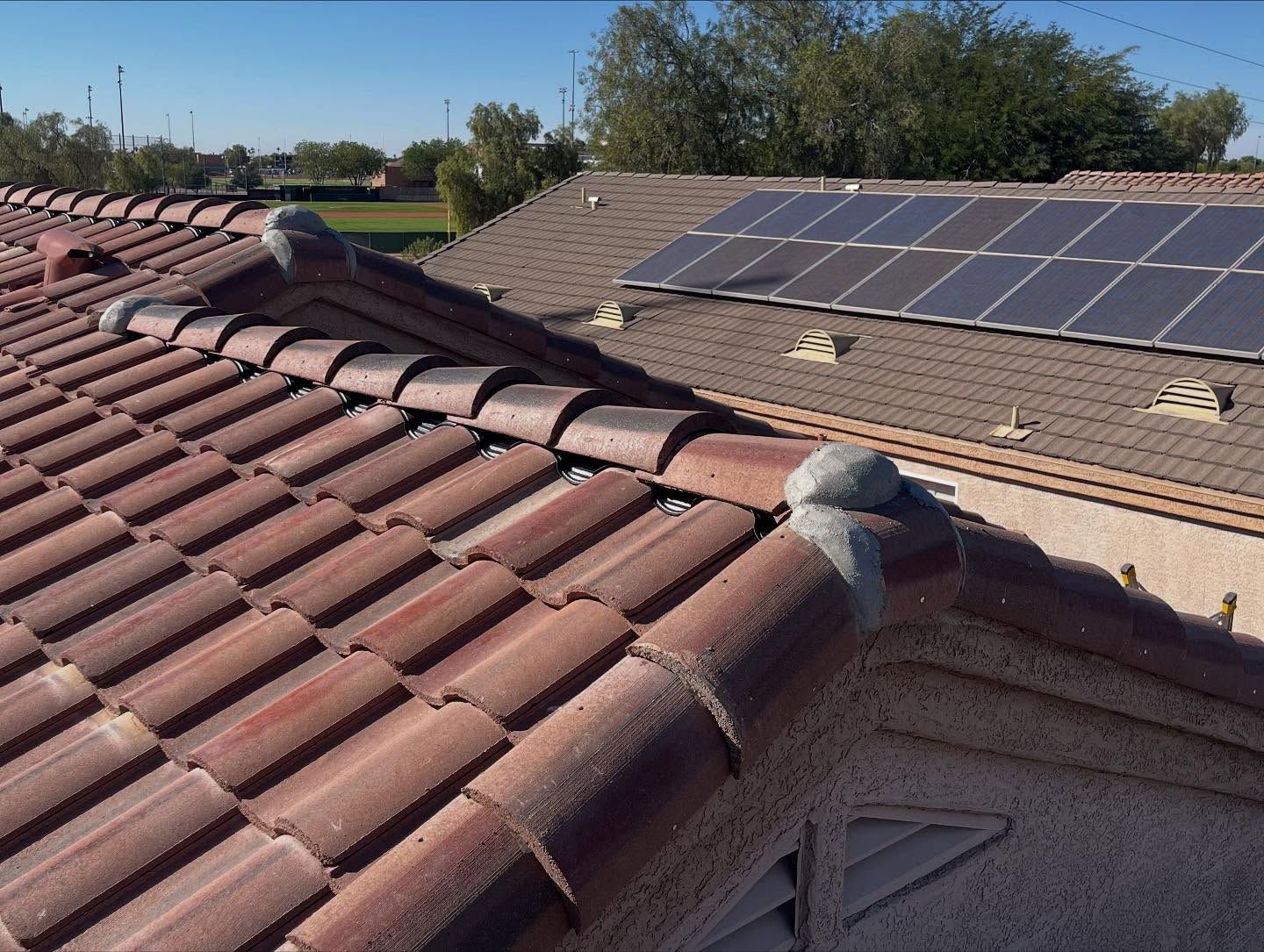 Red tile roof with solar panels.