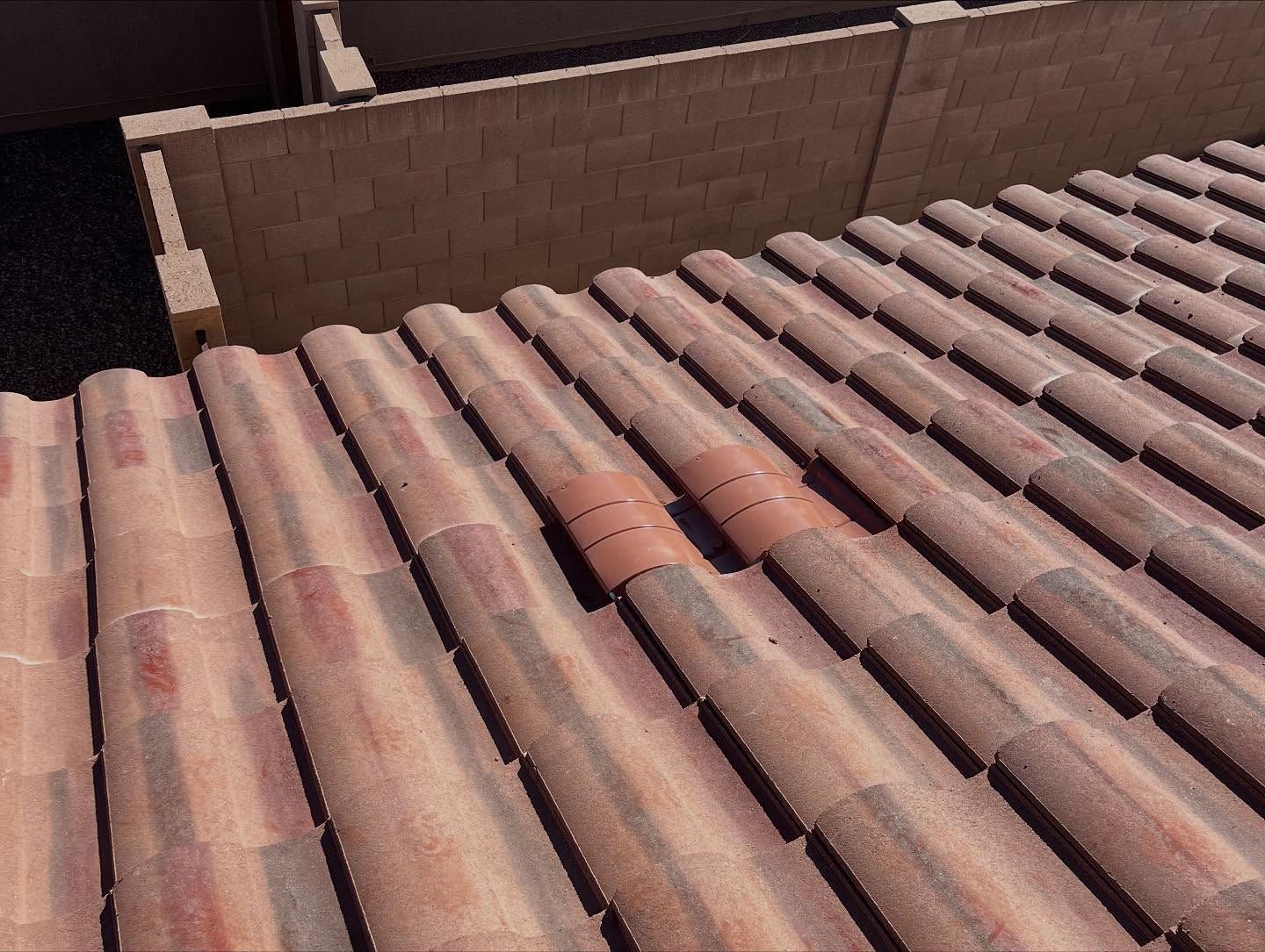Clay tile roof with several reddish-brown tiles; one section has darker orange tiles.