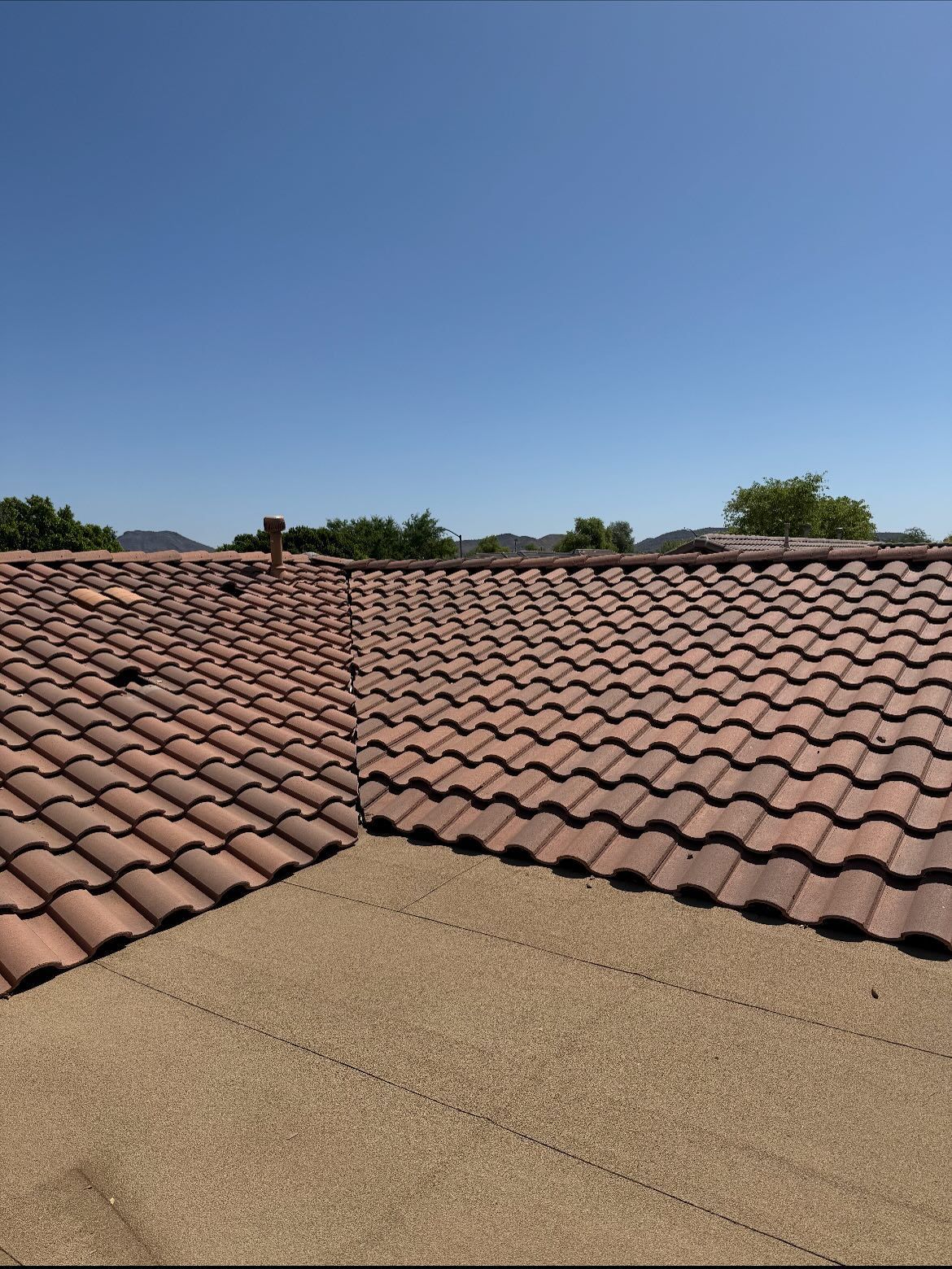 Brown tile roof with a clear blue sky background.