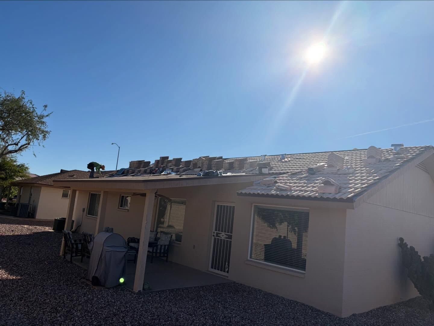 A house with a partially replaced roof under a bright sunny sky.