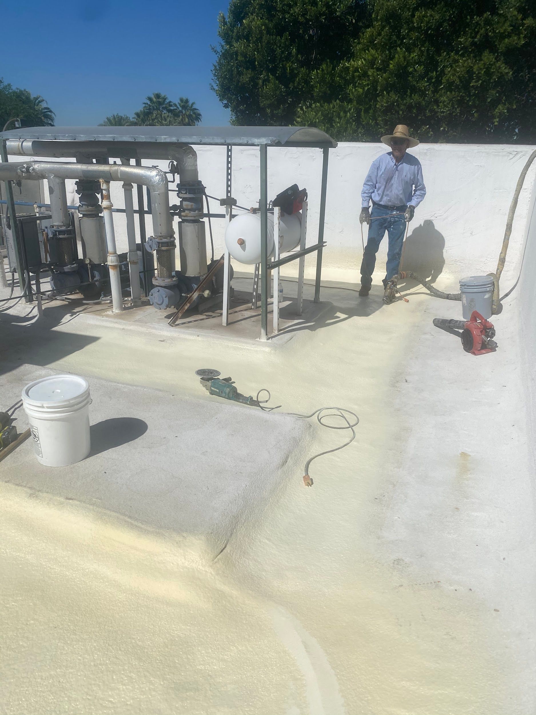 Pool equipment area with a person standing by a freshly coated surface; white and yellow colors.